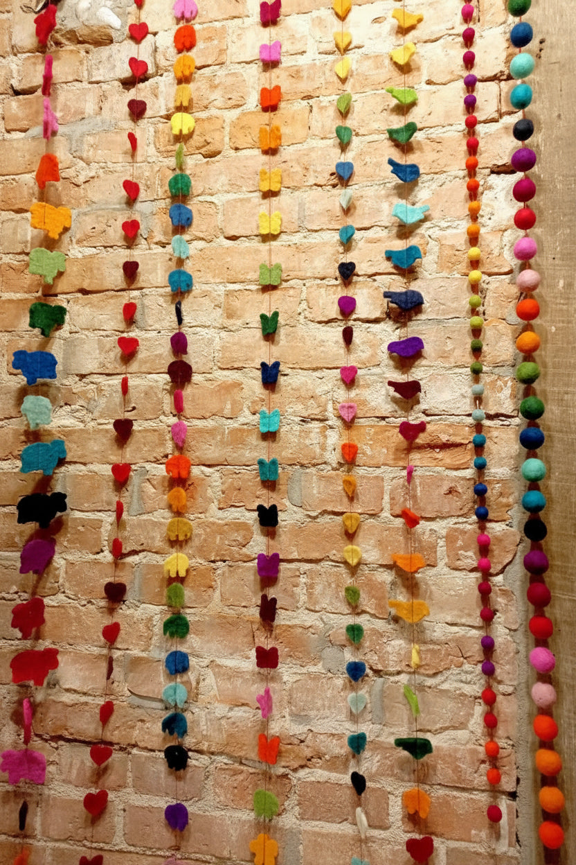Girlanden mit verschiedenen Filzfigurenmotiven an der Wand nebeneinander hängend
