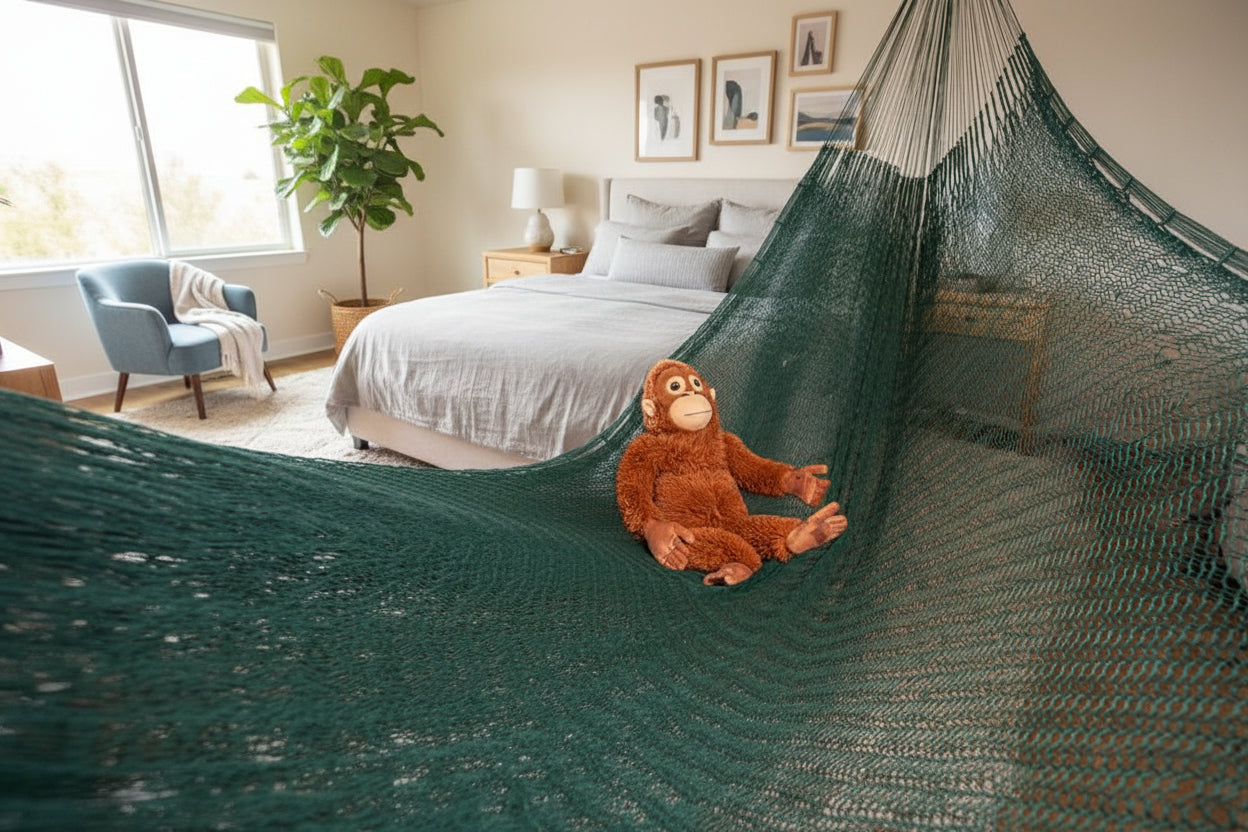 Dunkelgrüne mexikanische Netzhängematte im Schlafzimmer vor dem Bett aufgehängt