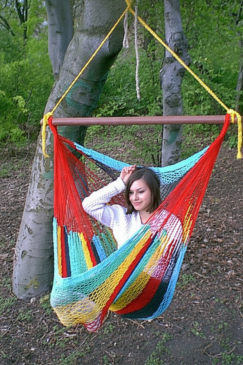 Frau sitzt im bunten Hängestuhl im Wald