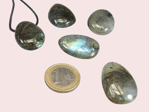 Gebohrte Trommelsteine in Steinsorte Labradorit in 5 verschienden Schattierungen im Größenvergleich mit 1€-Stück