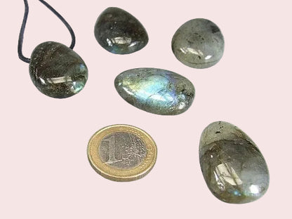 Gebohrte Trommelsteine in Steinsorte Labradorit in 5 verschienden Schattierungen im Größenvergleich mit 1€-Stück