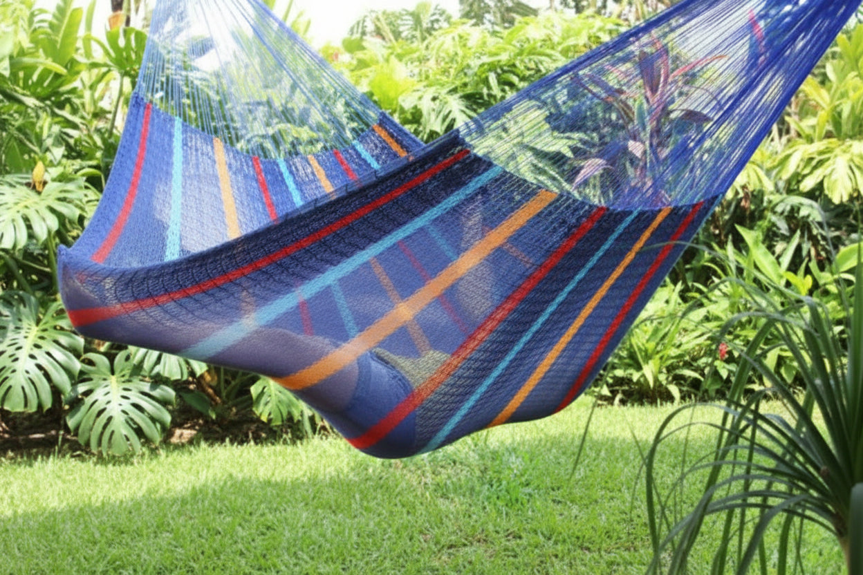 Hängematte in Blau-Bunt-Tönen im Garten mit darin quer liegender Person
